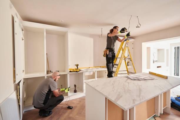 Workers renovating a residential kitchen with new cabinetry and an island bench in St Kilda, Victoria